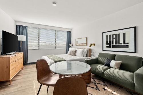 a living room with a couch and a table at Lodgeur Upper Kirby, Houston - Close to Greenway Plaza, Galleria, Montrose in Houston