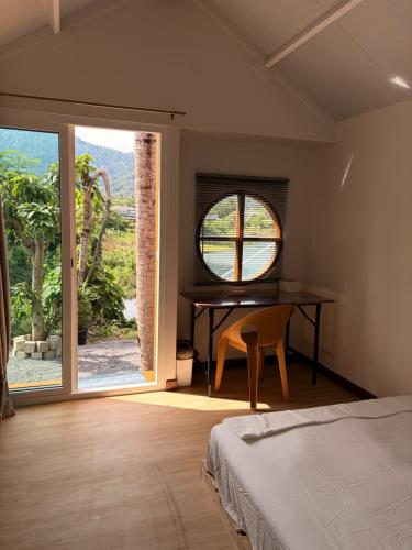 a bedroom with a bed and a desk and a window at Pangea Stay in Kathu