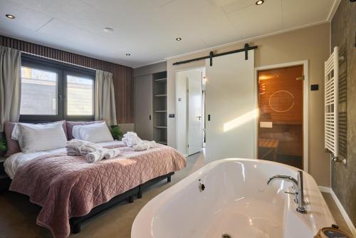 a bedroom with a bed and a bath tub at Slow Living bij Mölke x Wellnesslodges in Zuna
