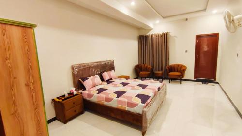 a bedroom with a bed and chairs in it at Hotel 26 in Islamabad