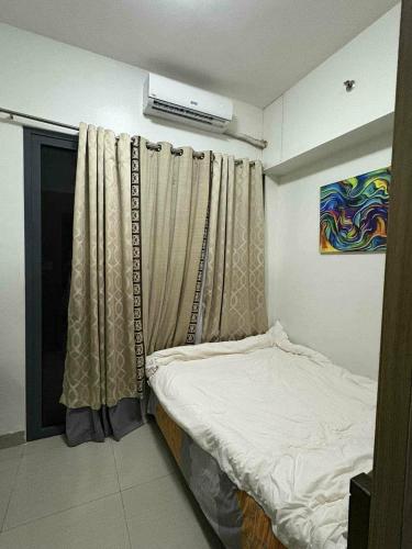 a small bedroom with a bed and a window at Staycation in Tropez 924 in Manila