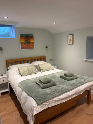 a bedroom with a large bed with two towels on it at The Bakehouse in Castlemorton