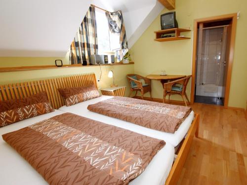 a bedroom with two beds and a table at Winzerhof Weber in Buggingen