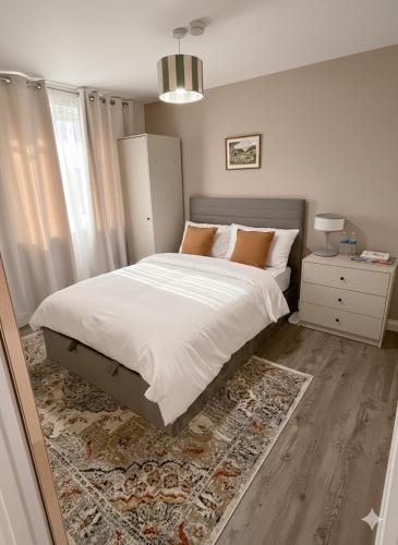 a bedroom with a large white bed and a rug at Stylish 3-Bed Maisonette - Sleeps 6 - Free Parking in Heswall