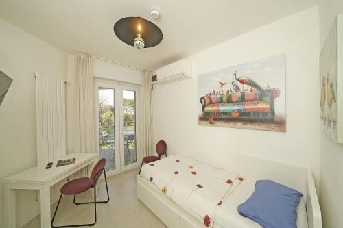 a bedroom with a bed and a desk and a window at Sunset on Sirmione in Sirmione