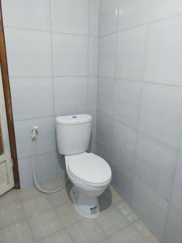 a bathroom with a toilet with a hose at SKY SUNSET Bungalows in Tetebatu