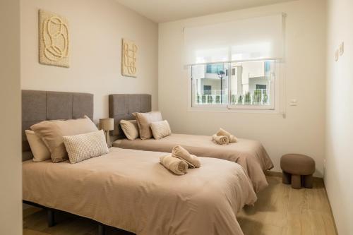 two beds in a room with a window at Casa Rico in Guardamar del Segura