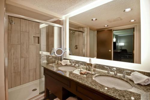 a bathroom with two sinks and a large mirror at DoubleTree by Hilton Hotel Augusta in Augusta