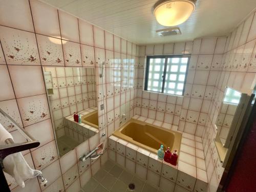 a bathroom with a tub and two mirrors at Hotel GALA Naha's only sandy beach front all rooms oceanview in Naha