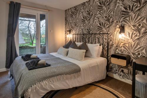 a bedroom with a bed with a black and white patterned wall at Finest Retreats - Toblerone Lodge in Callington