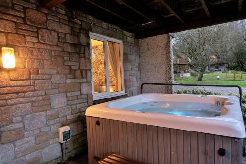 a jacuzzi tub sitting outside of a building at Finest Retreats - Toblerone Lodge in Callington