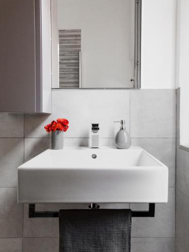 a white sink in a bathroom with a mirror at 2D - Home 32 Apartments in Modena