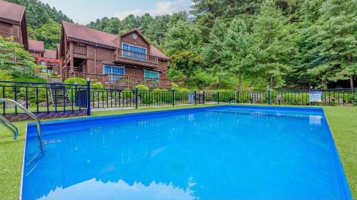 a large blue swimming pool in front of a house at Gapyeong Humantown Pension in Gapyeong