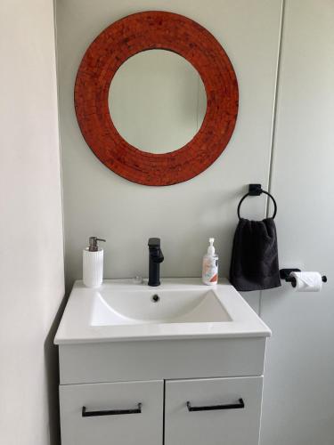 a bathroom with a white sink and a mirror at Hideaway on Honikiwi in Otorohanga
