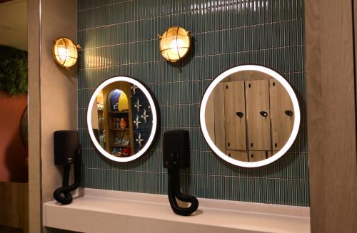 a bathroom with three mirrors on a green wall at Crescent 6 in Christchurch