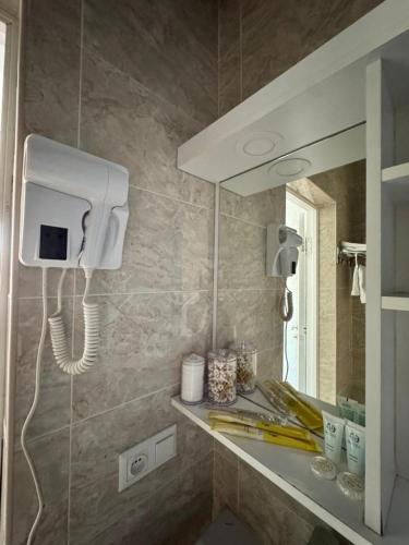 un bagno con un lavandino con un telefono sul muro di Garnet hotel a Bishkek