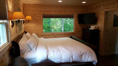 a bedroom with a bed in a log cabin at Brook Pointe Resort in Syracuse