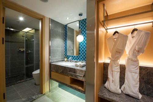 a bathroom with a sink and a shower and a toilet at Orange Crystal Hotel Nanjing Museum in Nanjing
