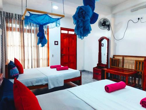 a room with two beds and a red door at Eco Diamond Palace in Ella
