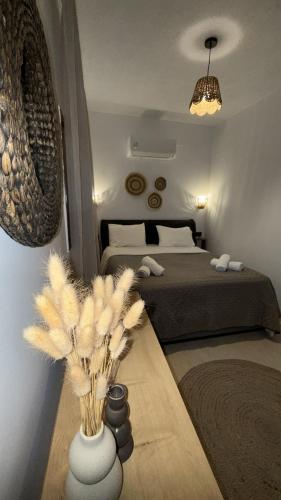 a bedroom with a bed and a vase with feathers at Dvillas one bedroom apartment in Svoronata