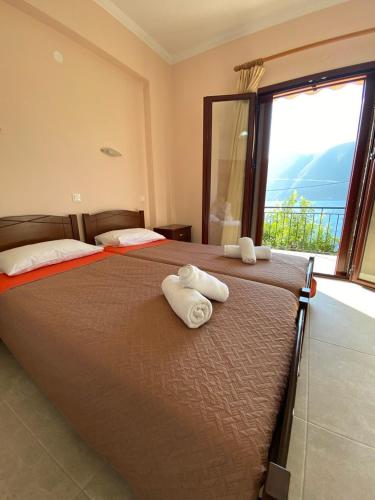 a bedroom with a large bed with towels on it at Studios&apartments Thomas in Vasiliki