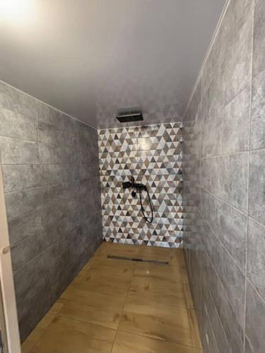 a bathroom with a shower with a tile wall at Mini Хаус Ясіня in Yasinya