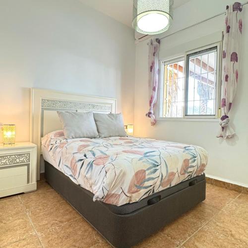 ein Schlafzimmer mit einem Bett und einem Fenster in der Unterkunft Casa Eclipse in Benajarafe