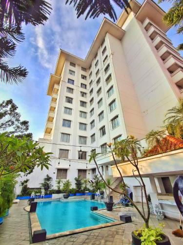 a hotel with a swimming pool in front of a building at Hotel Sahid Jaya Solo in Solo