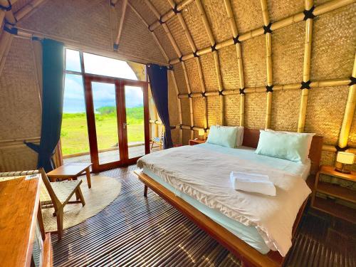 a bedroom with a bed in a room with a window at MareCoves Resort & Glamping in Cilangkahan