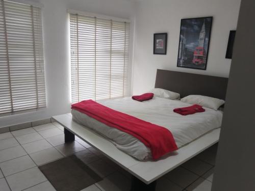 a bed with a red blanket on it in a bedroom at Elephant hide away in eMalahleni
