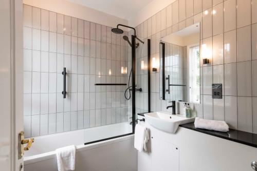 a bathroom with a tub and a sink and a shower at Wisteria Hotel in Oakham