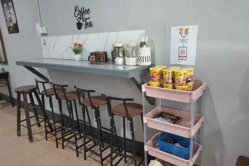 a counter with four stools under a table with food at Confidence Motel in Kuah