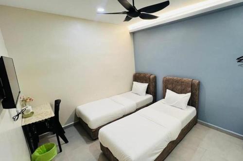 a room with two beds and a ceiling fan at Confidence Motel in Kuah