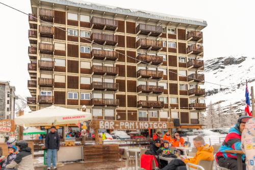 a group of people sitting at tables in front of a building at HelloCHALET - Front Row with balcony overlooking the Cretaz slopes in Breuil-Cervinia