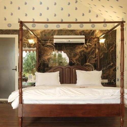 a canopy bed in a room with a wall at Innara Hospitality in Mori Bera