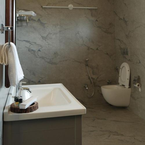 a bathroom with a sink and a toilet at Innara Hospitality in Mori Bera