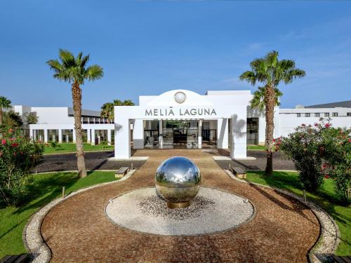 a building with a large silver ball in the middle of a fountain at Meliá Laguna Beach - Adults Only in Santa Maria