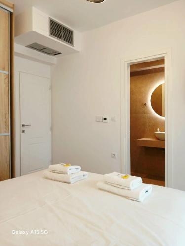 two white towels sitting on top of a bed at Lygonis White Houses in Mitika