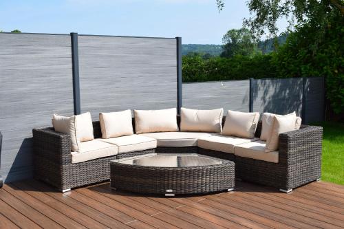 a wicker couch sitting on a deck with a coffee table at Number 3 in Trefriw