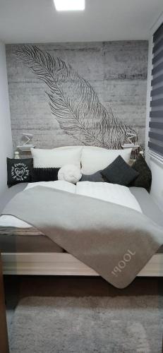 a bedroom with a bed with a wall mural at Apartman Marcel in Nijemci