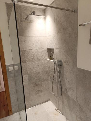 a shower with a glass door in a bathroom at Brunelle, Obertörgglerhof in Brixen