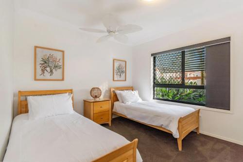 a bedroom with two beds and a window at The Breakers Yamba in Yamba