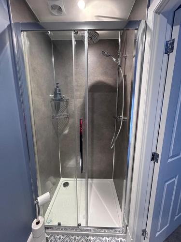 a shower with a glass door in a bathroom at Gruinard Guest House in Beauly