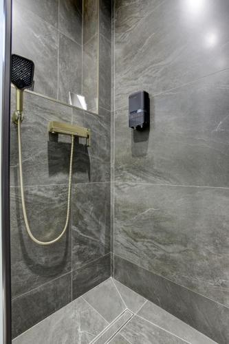 a bathroom with a shower with a soap dispenser at EV Hotel Baytik in Verkhnyaya Alaarcha