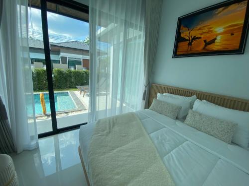 a bedroom with a white bed and a large window at The Casa Del Forest Ao-Nang in Ban Nong Thale