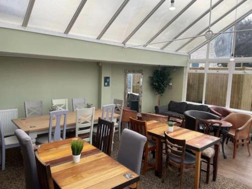 a room with tables and chairs and a couch at The Poacher Portishead in Portishead