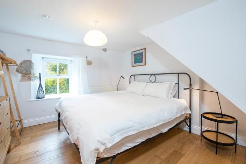 a bedroom with a large white bed in a attic at Ty Top in Newport