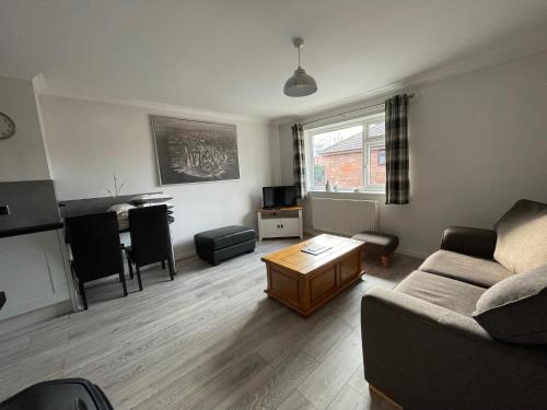 a living room with a couch and a table at The Mews in the heart of Stockton Heath in Warrington