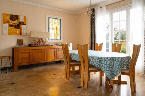 a dining room with a table and chairs and a window at Maison Le Reflet de Marne - Welkeys in Vaires-sur-Marne