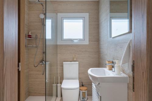 a bathroom with a toilet and a sink and a shower at Compass 1-BR Apartment by Makenzy Beach in Larnaca